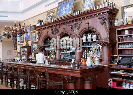 Un tabouret à l'ancienne bordées grand bar et comptoir avec bouteilles de boissons et une machine à café dans un bar restaurant. Tampa, en Floride, USA. Avril 2017 Banque D'Images