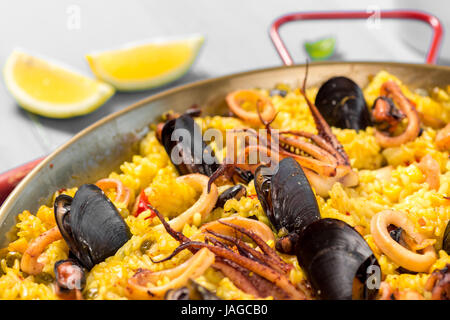 Paella aux fruits de mer dans un moule sur une table en bois rustique Banque D'Images