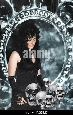 Femme vêtue de noir costume gothique avec têtes de mort dans l'image Banque D'Images