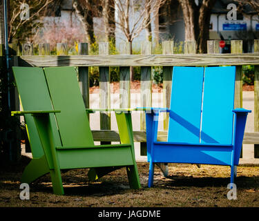 Deux couleurs, bleu et vert, des chaises Adirondack dans un patio extérieur. Banque D'Images