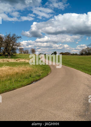 Route de campagne Anglais étroites et sinueuses, de disparaître plus d'horizon avec ciel bleu et les nuages blancs au-dessus, England, UK Banque D'Images