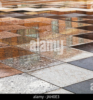 Les flaques de pluie sur pierres naturelles de place urbaine Banque D'Images