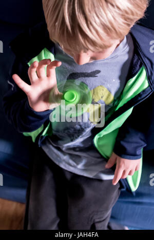 Un garçon joue avec un spinner fidget à la maison, le controversé stress relief toy pour aider certains enfants autistes antsy ou se concentrer à l'école Banque D'Images