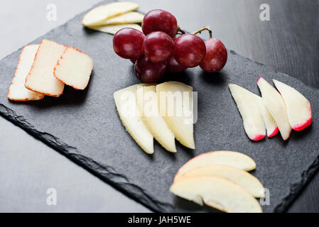 Plateau de fromages mixtes gastronomique starter tapas avec apple et le raisin snack Banque D'Images