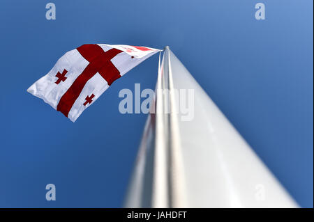 Drapeau national de Géorgie soufflé par le vent contre un ciel bleu Banque D'Images