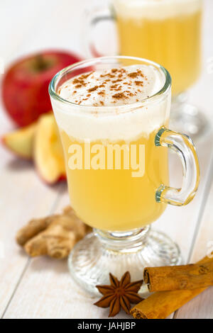 Apple fait chaud maison punch jus de pommes, de gingembre, d'anis et de la cannelle la cannelle avec de la crème fouettée sur le dessus (Selective Focus, se concentrer sur l'avant de la crème fouettée) Banque D'Images