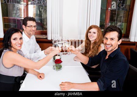 Gemischte Gruppe Menschen im lachend Restaurant am Tisch Unterhaltung trinken le dîner Banque D'Images