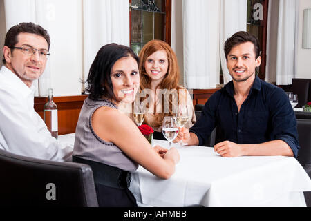 Gemischte Gruppe Menschen im lachend Restaurant am Tisch Unterhaltung trinken le dîner Banque D'Images