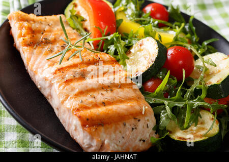 Belle et délicieuse nourriture : filets de saumon grillés et roquette salade de légumes avec gros plan sur une plaque horizontale. Banque D'Images