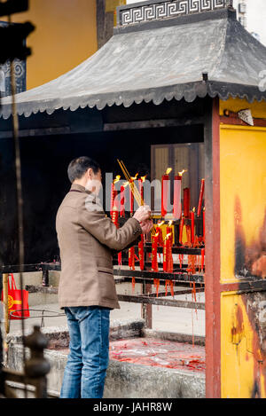 Bougies et lumières adorateur à parfumeront Temple de mystère, un complexe taoïste fondée en Dynastie Song, Suzhou, Province de Jiangsu, Chine Banque D'Images