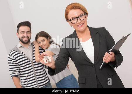 Agent immobilier est prêt à remettre les clés d'un appartement à de nouveaux propriétaires après la signature de l'accord. Banque D'Images