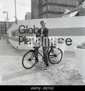 L'acteur et réalisateur Sam Wanamaker sur sa bicyclette à l'extérieur de son site proposé pour le Globe Playhouse Theatre à Londres en 1972. La Sam Wanamaker Playhouse est un théâtre intérieur faisant partie de Shakespeare's Globe, de même que le Globe Theatre, London Bankside sur. Construit en utilisant des plans du 17e siècle pour un théâtre intérieur, la Playhouse rappelle la mise en page et le style du théâtre de Blackfriars, bien qu'il n'est pas une reconstruction exacte. Sa coquille a été construit lors de la construction de la complexité du Globe de Shakespeare, remarquable pour la reconstruction de l'open-air Globe Theatre de la même période. Banque D'Images