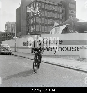 L'acteur et réalisateur Sam Wanamaker sur sa bicyclette à l'extérieur de son site proposé pour le Globe Playhouse Theatre à Londres en 1972. La Sam Wanamaker Playhouse est un théâtre intérieur faisant partie de Shakespeare's Globe, de même que le Globe Theatre, London Bankside sur. Construit en utilisant des plans du 17e siècle pour un théâtre intérieur, la Playhouse rappelle la mise en page et le style du théâtre de Blackfriars, bien qu'il n'est pas une reconstruction exacte. Sa coquille a été construit lors de la construction de la complexité du Globe de Shakespeare, remarquable pour la reconstruction de l'open-air Globe Theatre de la même période. Banque D'Images