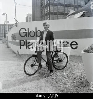 L'acteur et réalisateur Sam Wanamaker sur sa bicyclette à l'extérieur de son site proposé pour le Globe Playhouse Theatre à Londres en 1972. La Sam Wanamaker Playhouse est un théâtre intérieur faisant partie de Shakespeare's Globe, de même que le Globe Theatre, London Bankside sur. Construit en utilisant des plans du 17e siècle pour un théâtre intérieur, la Playhouse rappelle la mise en page et le style du théâtre de Blackfriars, bien qu'il n'est pas une reconstruction exacte. Sa coquille a été construit lors de la construction de la complexité du Globe de Shakespeare, remarquable pour la reconstruction de l'open-air Globe Theatre de la même période. Banque D'Images