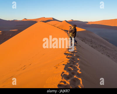 SOUSSUSVLEI, NAMIBIE - 20 juin 2016 : Les gens qui suivent le lever du soleil la forme dune 45 dans la région de Sossusvlei du désert du Namib en Namibie. Banque D'Images