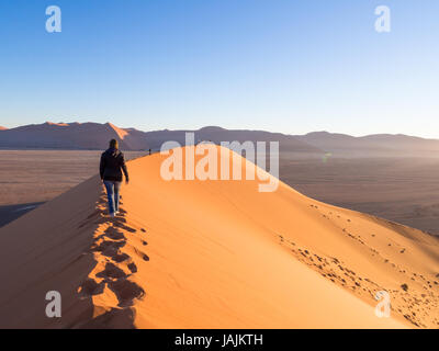 SOUSSUSVLEI, NAMIBIE - 20 juin 2016 : Les gens qui suivent le lever du soleil la forme dune 45 dans la région de Sossusvlei du désert du Namib en Namibie. Banque D'Images