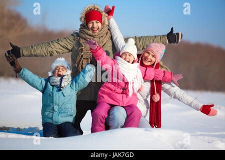 Heureux les parents et leurs enfants en s'amusant winterwear en dehors Banque D'Images