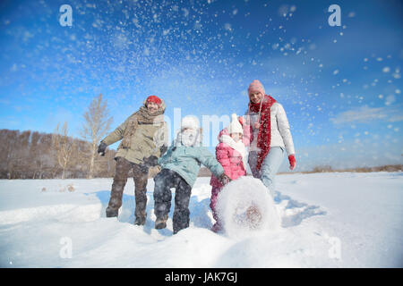 Heureux les parents et leurs enfants en s'amusant winterwear en dehors Banque D'Images