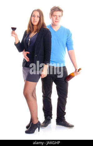 Ein junger Mann und eine junge Frau stehen nebeneinander, Sie ein Glas Wein und hält er eine Weinflasche in der Hand. Vor Freigestellt weißem Hintergrund. Banque D'Images