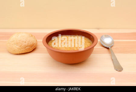 Soupe aux lentilles copieux servi dans un bol avec un rouleau de pain croûté Banque D'Images