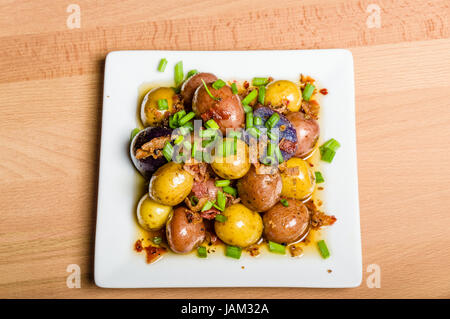 Des pommes de terre bouillies et habillés de servir sur une assiette blanche Banque D'Images