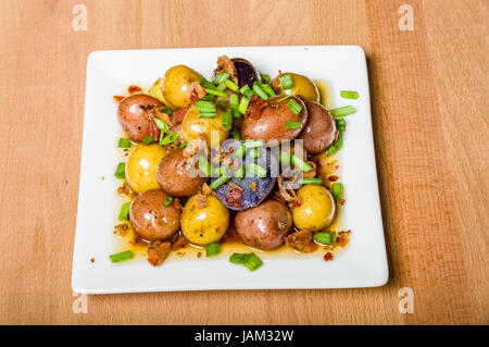 Des pommes de terre bouillies et habillés de servir sur une assiette blanche Banque D'Images