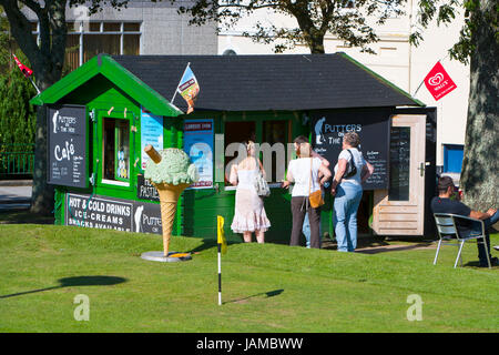 Les jeunes adultes d'acheter des rafraîchissements, du café vert cabane sur un golf à l'extérieur dans le soleil en été journée ensoleillée. grand green ice cream cone Banque D'Images