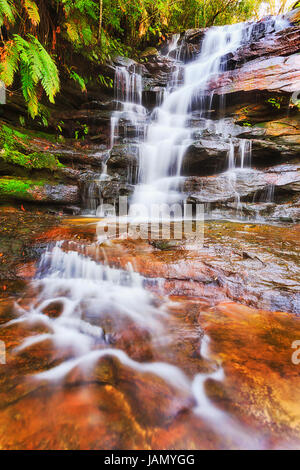 Vue rapprochée de la pluie-forest waterfall cascade - Somersby falls sur la côte centrale de l'Australie. Flux rapide frais tombe vers le bas à travers les rochers de grès dow Banque D'Images