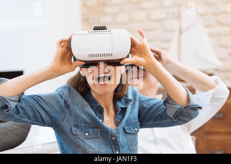 D'âge mûr à l'aide de casque de réalité virtuelle dans la salle de séjour Banque D'Images