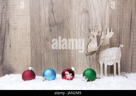 Weihnachten, Dekoration, Holzhintergrund mit Schnee und Weihnachtskugeln Elch, rot, Blau, grün Banque D'Images