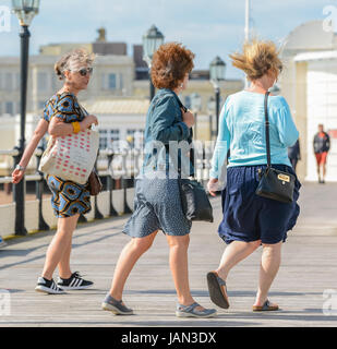 Jour de vent. La Marche des femmes sur une station pier dans le vent par un jour de vent. Banque D'Images
