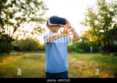 Petit garçon fasciné en utilisant des lunettes de réalité virtuelle VR. Banque D'Images