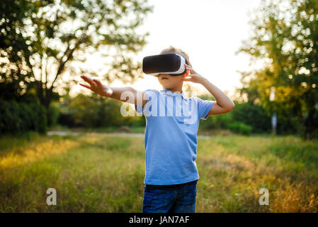 Petit garçon fasciné en utilisant des lunettes de réalité virtuelle VR. Banque D'Images