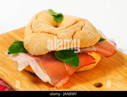 Le pain en forme d'anneau (rouleau) friselle avec des tranches de jambon sec Banque D'Images