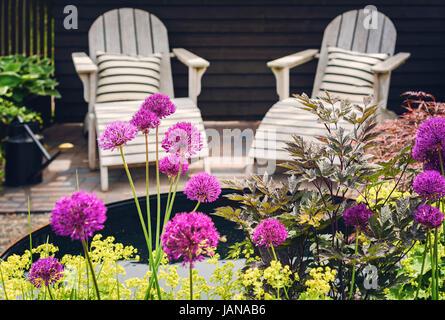 Meubles de salon confortable sur la terrasse du jardin paysager. Banque D'Images