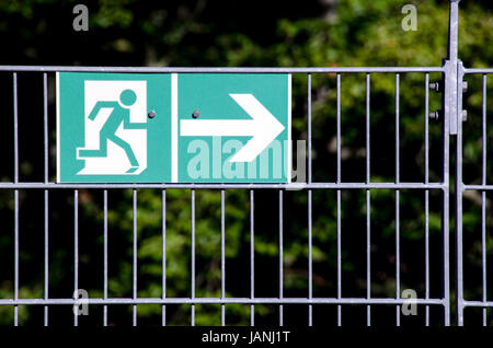 Green escape route signe sur une clôture métallique Banque D'Images