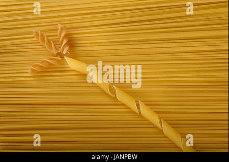 Penne fusilli et non cuite sur fond de spaghetti Banque D'Images