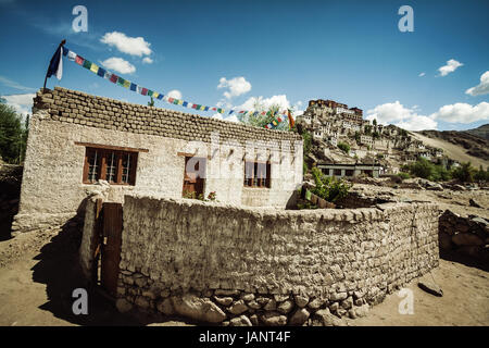 Maison de style tibétain au village qui se trouve directement en dessous du Thiske Gompa bouddhiste avec les drapeaux de prières bouddhistes tibétains voletant dans le vent Banque D'Images