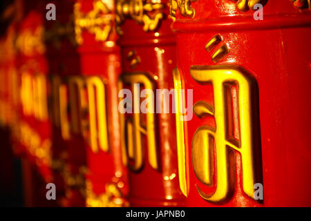 Roues de prière bouddhiste rouge avec lettres d'or de la prière, Close up. Banque D'Images