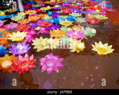 La prière rituelle de bougies colorées flottant sur l'eau pour prier bouddha à Wat Phra Pathommachedi Ratcha Wora Wihan Maha dans Nakhon Pathom, Thaïlande Banque D'Images