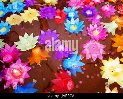 La prière rituelle de bougies colorées flottant sur l'eau pour prier bouddha à Wat Phra Pathommachedi Ratcha Wora Wihan Maha dans Nakhon Pathom, Thaïlande Banque D'Images