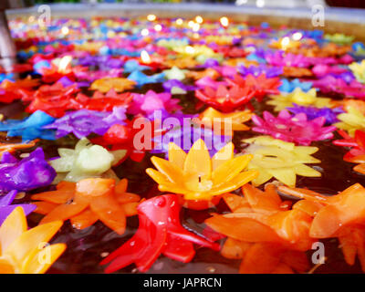 La prière rituelle de bougies colorées flottant sur l'eau pour prier bouddha à Wat Phra Pathommachedi Ratcha Wora Wihan Maha dans Nakhon Pathom, Thaïlande Banque D'Images