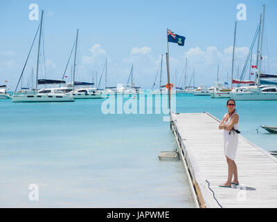 Femme debout sur le quai avec une vue de voiliers dans la mer des Caraïbes des îles Vierges britanniques Banque D'Images