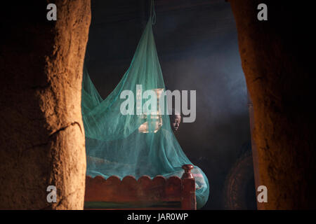 Une moustiquaire remettant un lit dans un refuge au Kenya, Afrique. Banque D'Images