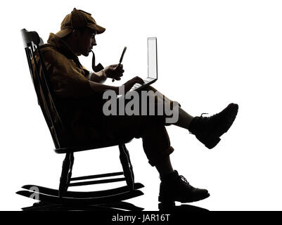 Sherlock Holmes avec ordinateur portable silhouette assise dans un fauteuil à bascule en studio sur fond blanc Banque D'Images