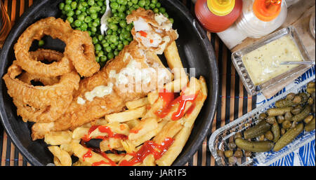 De haut en bas vue de l'anglais fish and chips avec petits pois, oignons et sauce tartare anneau Banque D'Images