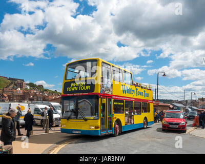 Un jaune vif garni ouvert bus à impériale qui emmène les touristes sur un tour autour de la station balnéaire de Whitby Banque D'Images