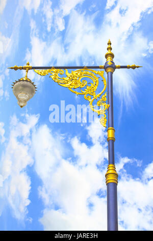 Pôle éclairage doré sur fond bleu ciel, statue de style Thaï Banque D'Images