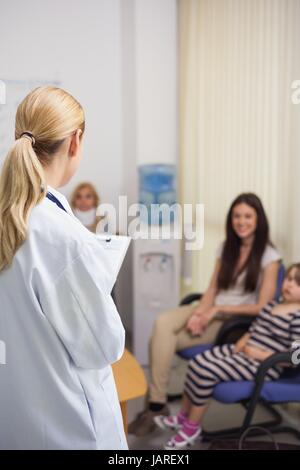 Blonde doctor talking to patient dans une salle d'attente Banque D'Images