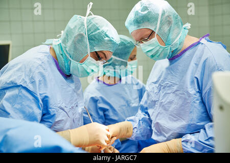 Équipe de chirurgiens et d'infirmières d'effectuer la chirurgie mini-invasive laparoscopique Banque D'Images